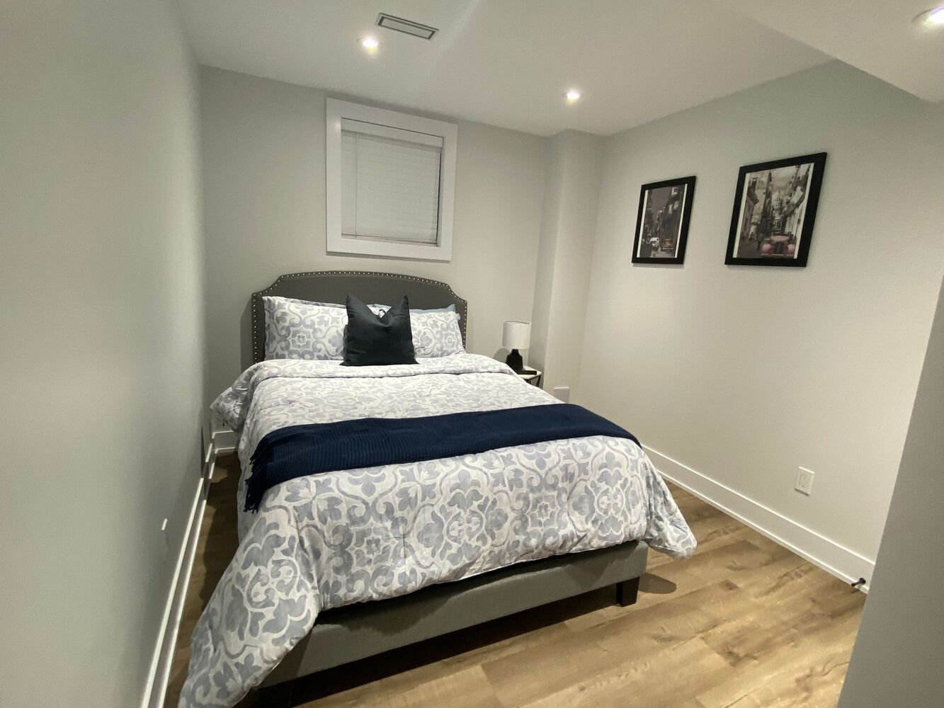 Basement entertainment room with large TV and seating